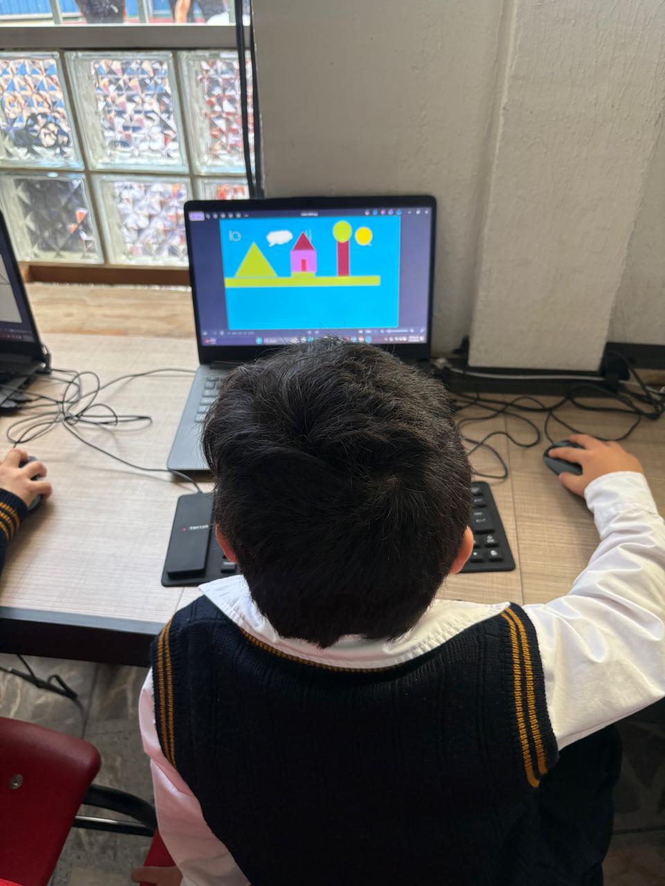 Alumno de preescolar dibujando en computadora