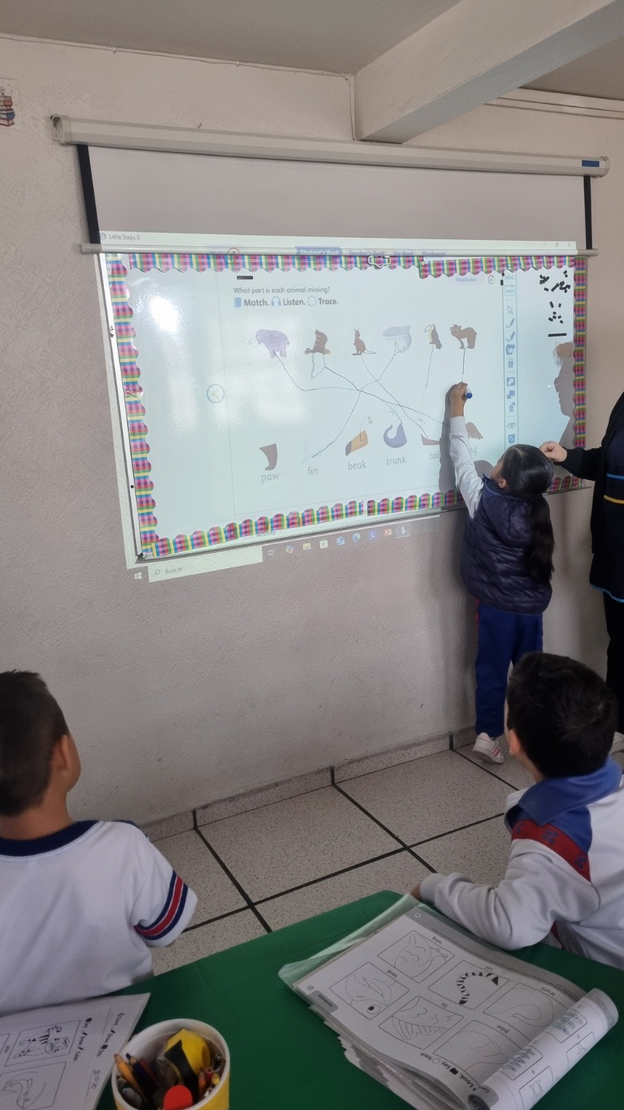 Alumnos trabajando en clase de inglés con pizarrón interactivo